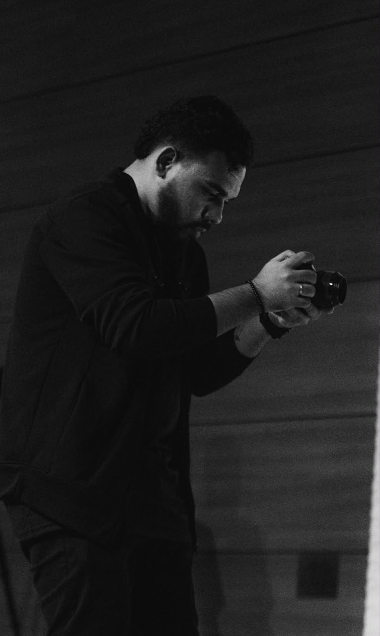 Guilherme segurando uma camera em um registro em preto e branco